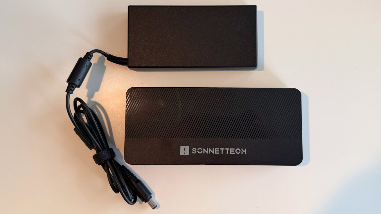 Black power adapter with cord and a textured rectangular electronic device labeled Sonnetech on a white surface.
